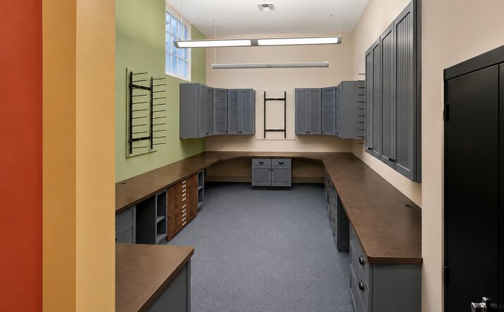 Modern office utility room with gray cabinets, brown countertops, and natural light from a large window.